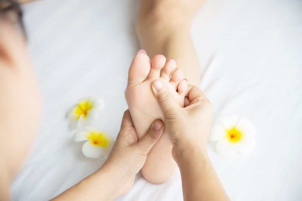 woman-receiving-foot-massage-service-from-masseuse-close-up-hand-foot-relax-foot-massage-therapy-service-concept-min